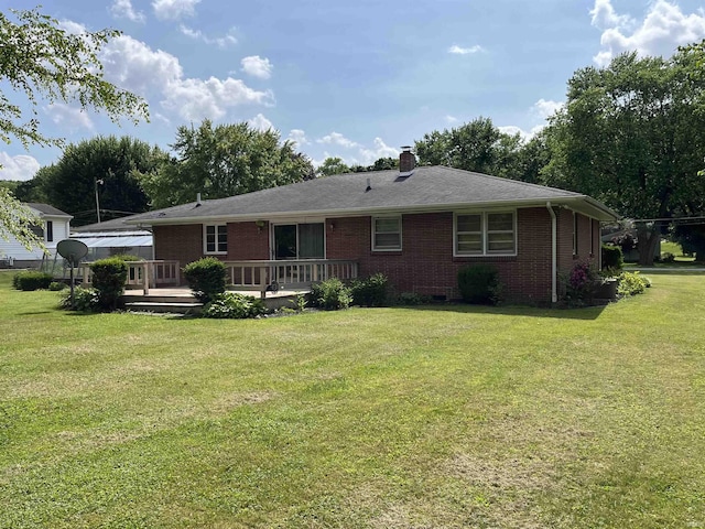 2127 Flora Dr, Peru, IN 46970 - back of house with brick siding, a yard, a chimney, and a wooden deck
