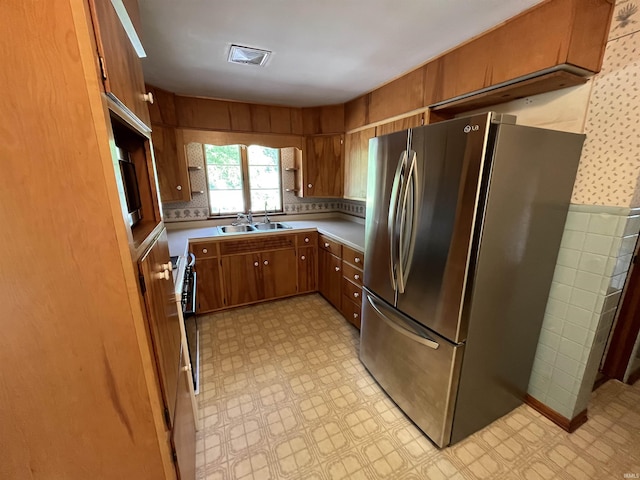 2127 Flora Dr, Peru, IN 46970 - kitchen featuring freestanding refrigerator, light flooring, brown cabinets, and light countertops