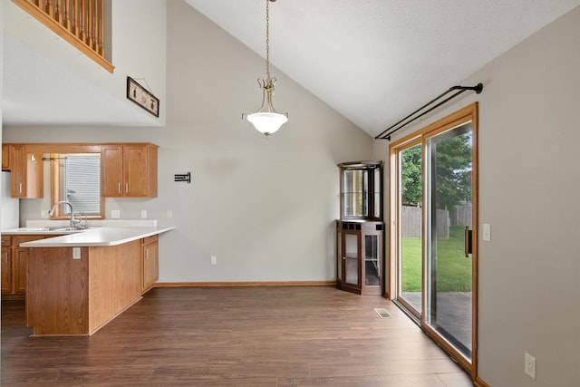 5130 Windy Knoll Ct, Fort Wayne, IN 46809 - kitchen featuring dark wood-style floors, a peninsula, light countertops, high vaulted ceiling, and decorative light fixtures