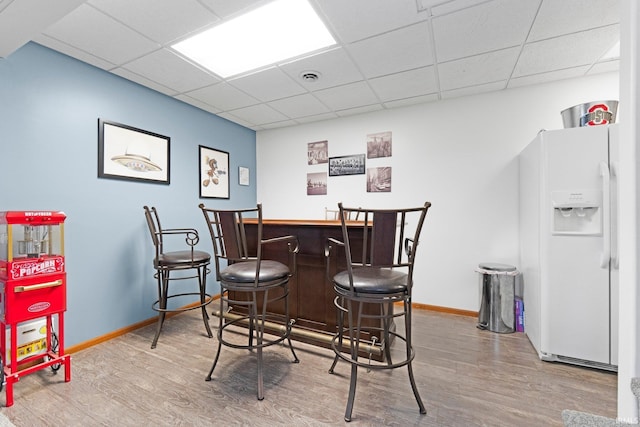 11301 Clarendon Pass, Fort Wayne, IN 46845 - indoor dry bar featuring white fridge with ice dispenser, wood finished floors, and a drop ceiling
