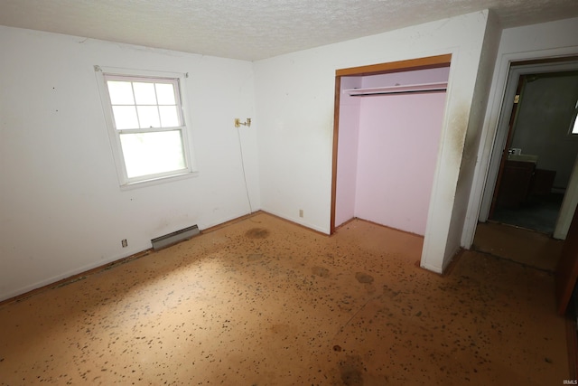 310 W Elm St, Millersburg, IN 46543 - unfurnished bedroom featuring baseboard heating, a closet, and a textured ceiling