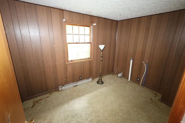 310 W Elm St, Millersburg, IN 46543 - empty room with a baseboard heating unit, a textured ceiling, and wooden walls