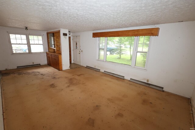 310 W Elm St, Millersburg, IN 46543 - unfurnished room with baseboard heating, a baseboard radiator, a textured ceiling, and unfinished concrete floors