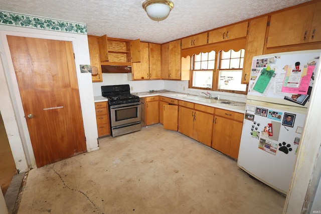 310 W Elm St, Millersburg, IN 46543 - kitchen featuring freestanding refrigerator, gas range, light countertops, under cabinet range hood, and brown cabinetry