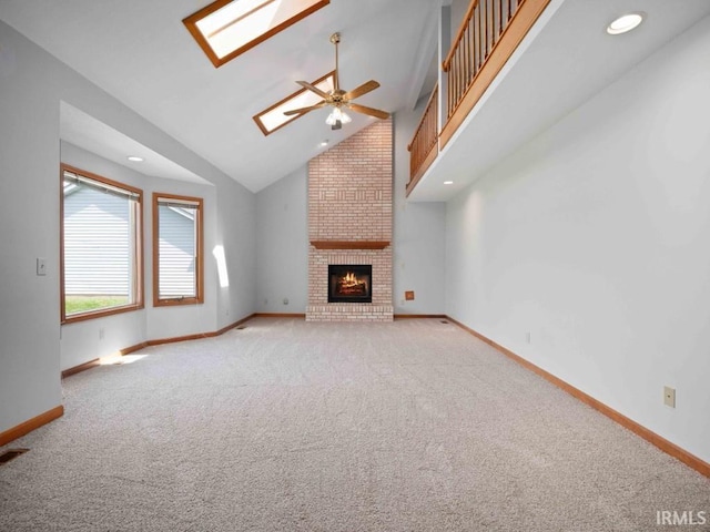 624 Diamond Point Pl, Fort Wayne, IN 46804 - unfurnished living room featuring carpet, a skylight, a ceiling fan, a fireplace, and high vaulted ceiling