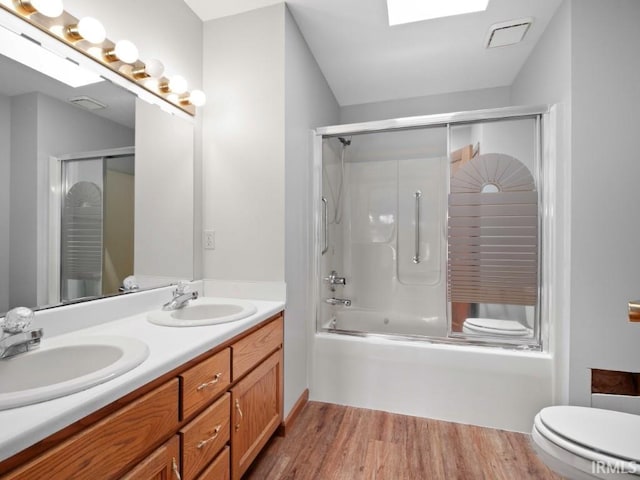 624 Diamond Point Pl, Fort Wayne, IN 46804 - bathroom with double vanity, shower / bath combination with glass door, wood finished floors, and a skylight