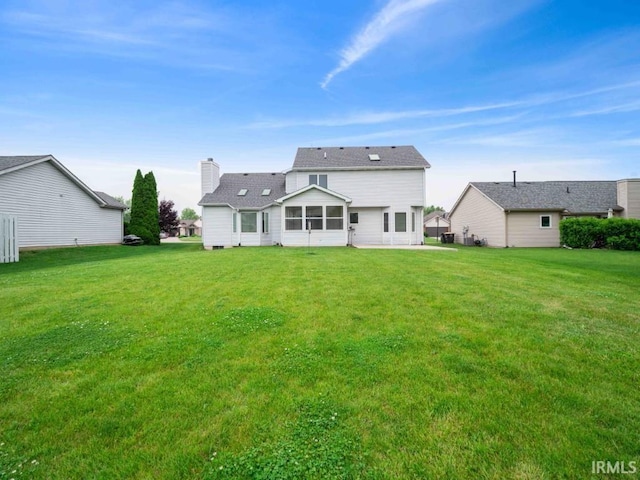 624 Diamond Point Pl, Fort Wayne, IN 46804 - back of house featuring a chimney, a yard, a shingled roof, and a sunroom