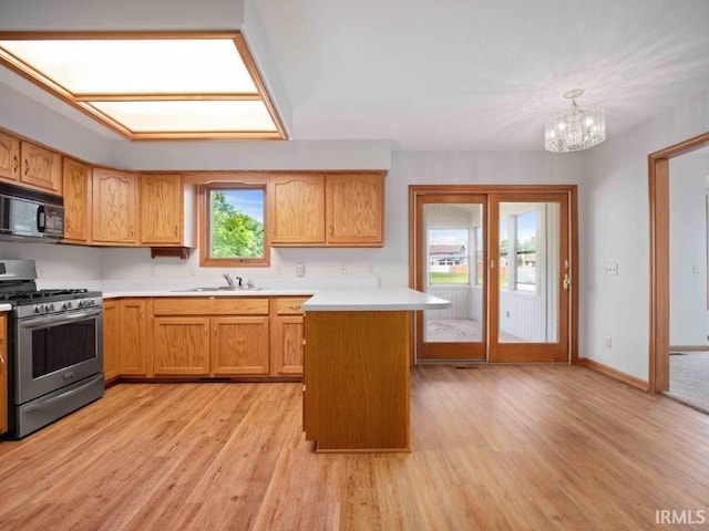 624 Diamond Point Pl, Fort Wayne, IN 46804 - kitchen featuring stainless steel gas range, black microwave, light countertops, light wood finished floors, and a chandelier