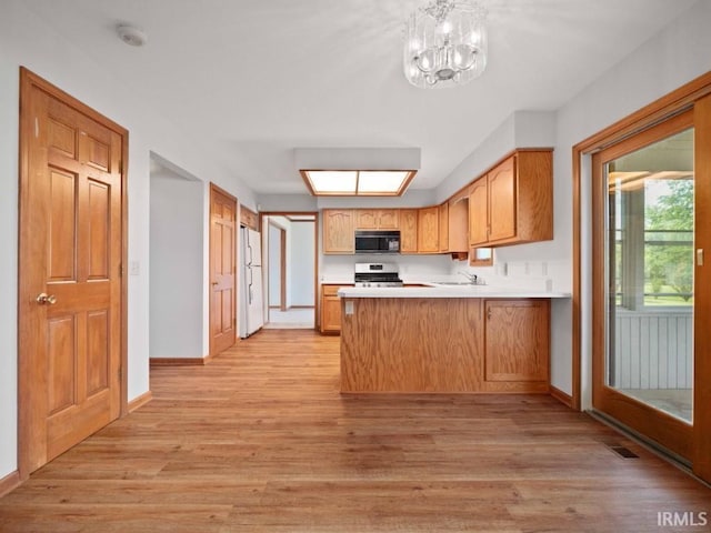 624 Diamond Point Pl, Fort Wayne, IN 46804 - kitchen with black microwave, freestanding refrigerator, a peninsula, stainless steel range, and light wood-style flooring