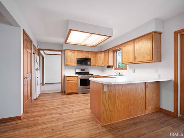 624 Diamond Point Pl, Fort Wayne, IN 46804 - kitchen featuring gas range, black microwave, a peninsula, light countertops, and light wood-style floors