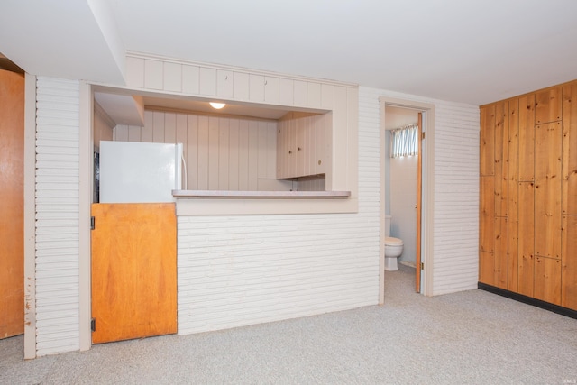 7811 Meadowview Dr, Evansville, IN 47710 - kitchen with freestanding refrigerator, carpet floors, and wooden walls