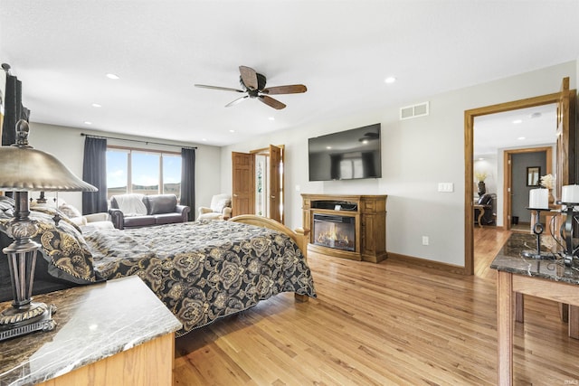 17818 Amstutz Rd, Leo, IN 46765 - bedroom with light wood finished floors, a glass covered fireplace, recessed lighting, and ceiling fan