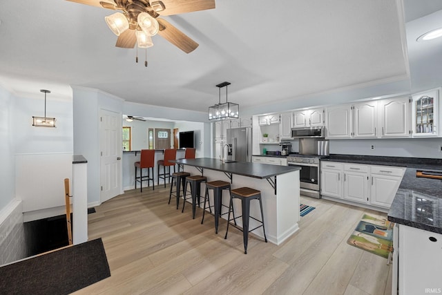 2131 E 430 Rd S, Lafayette, IN 47909 - kitchen with stainless steel appliances, ceiling fan, a breakfast bar, dark countertops, and light wood-style floors