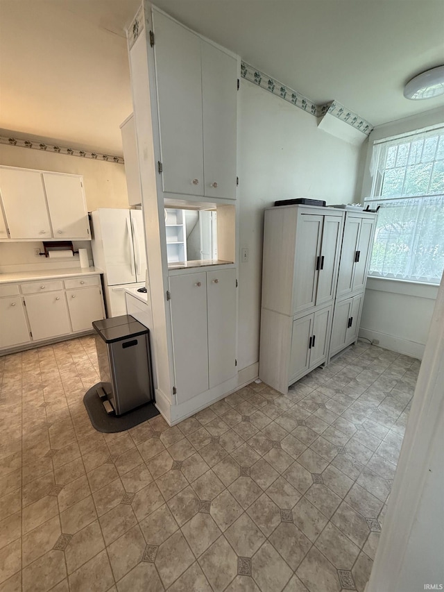 217 S 9th St, Vincennes, IN 47591 - kitchen with freestanding refrigerator, light countertops, and white cabinets