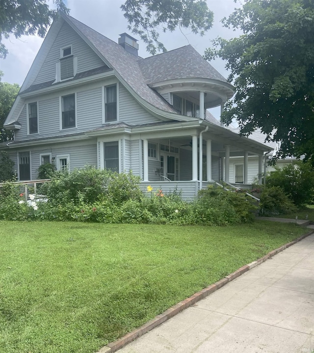 217 S 9th St, Vincennes, IN 47591 - view of front facade with a porch, a front yard, a chimney, and roof with shingles