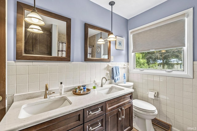 60175 Emerald Dr, South Bend, IN 46614 - full bath featuring tile walls, double vanity, a shower with curtain, and wainscoting