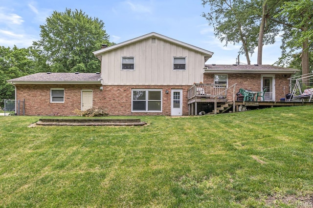 60175 Emerald Dr, South Bend, IN 46614 - rear view of house featuring brick siding, a lawn, a deck, and board and batten siding