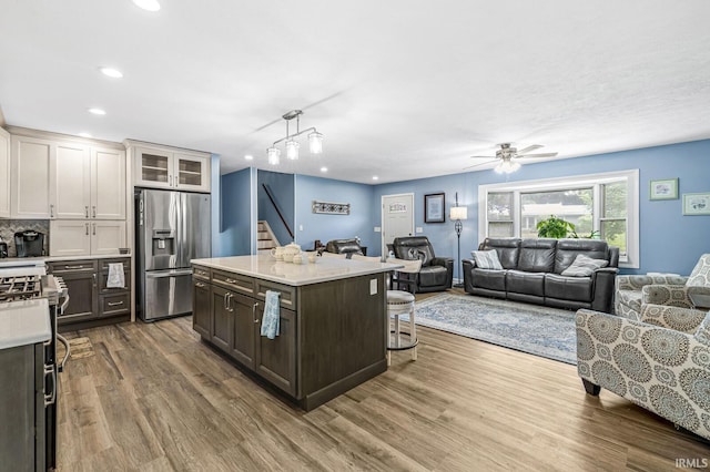 60175 Emerald Dr, South Bend, IN 46614 - kitchen featuring appliances with stainless steel finishes, open floor plan, light countertops, a kitchen bar, and ceiling fan