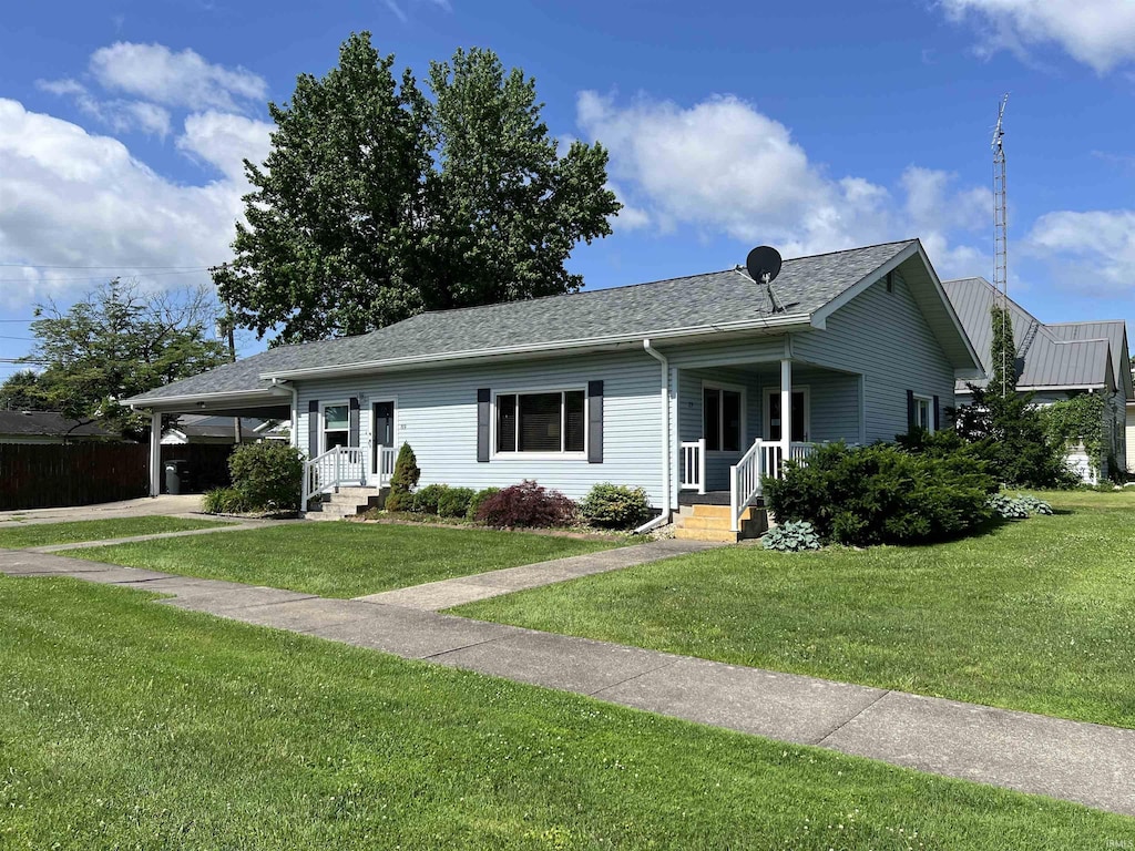 89 NE H St, Linton, IN 47441 - single story home featuring a front lawn, a carport, driveway, and roof with shingles