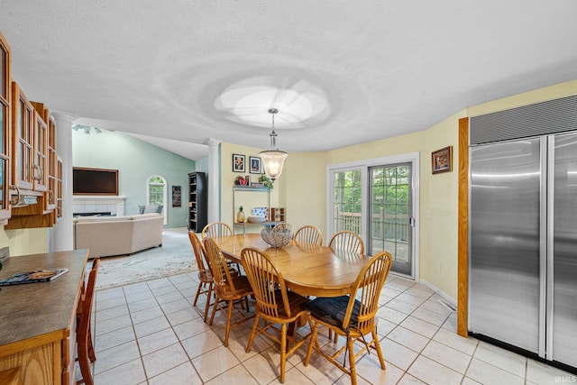 2166 Willow Creek Dr, Mishawaka, IN 46545 - dining room with light tile patterned floors, a textured ceiling, ornate columns, and a tiled fireplace