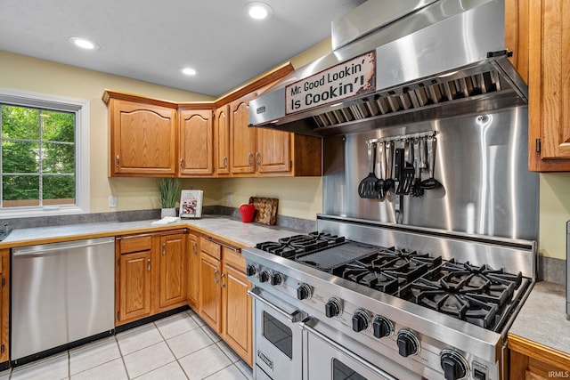 2166 Willow Creek Dr, Mishawaka, IN 46545 - kitchen with stainless steel appliances, light countertops, light tile patterned flooring, recessed lighting, and brown cabinetry