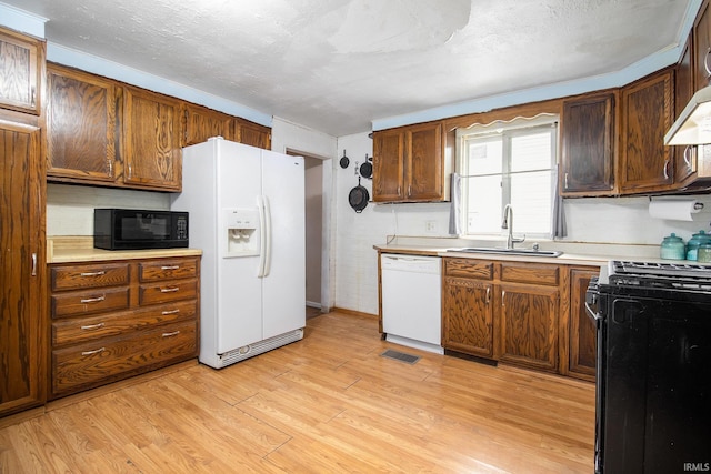 227 E Marion St, Mishawaka, IN 46545 - kitchen with white appliances, light wood-style floors, light countertops, and range hood