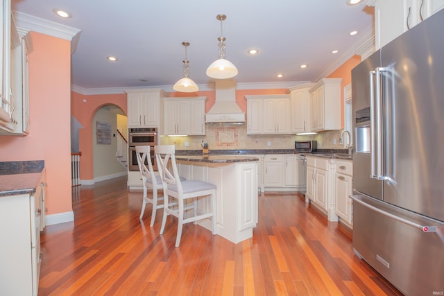 6488 Pebble Pointe Ct, Newburgh, IN 47630 - kitchen with stainless steel appliances, premium range hood, dark countertops, crown molding, and light wood-style flooring