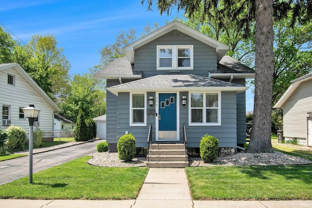 909 Independence St, Elkhart, IN 46514 - view of front of property featuring entry steps, a shingled roof, a front lawn, and a detached garage