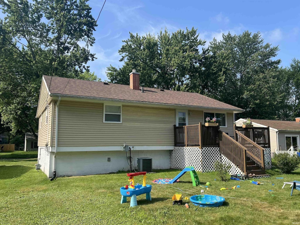 1507 W Ave, Goshen, IN 46526 - rear view of property featuring a chimney, a yard, a deck, and a shingled roof