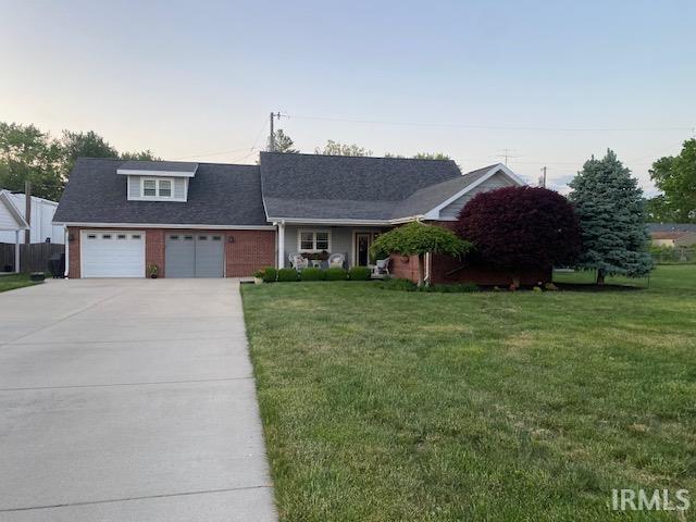 601 Railroad St, Covington, IN 47932 - view of front of home with concrete driveway, a lawn, and an attached garage