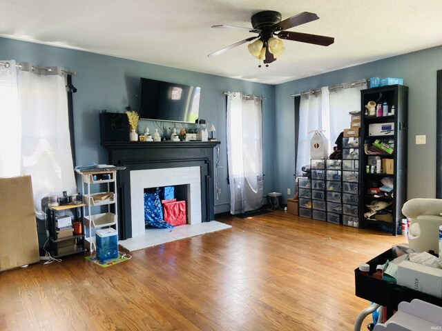 706 11th St, Tell City, IN 47586 - living area featuring a ceiling fan, a fireplace with flush hearth, and wood finished floors