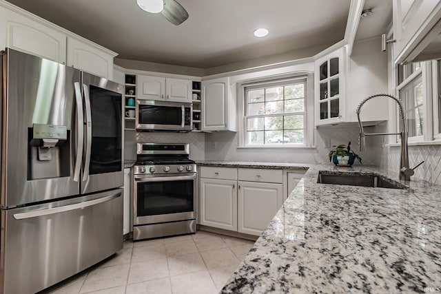 2200 E Boonville New Harmony Rd, Evansville, IN 47725 - kitchen with appliances with stainless steel finishes, open shelves, light stone counters, light tile patterned floors, and white cabinetry