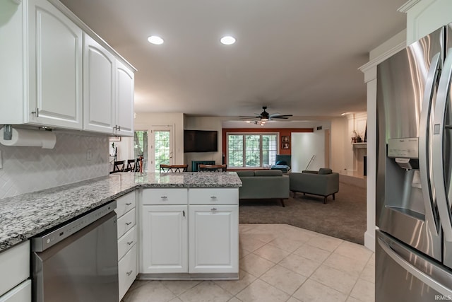 2200 E Boonville New Harmony Rd, Evansville, IN 47725 - kitchen with stainless steel appliances, light colored carpet, a peninsula, ceiling fan, and white cabinetry
