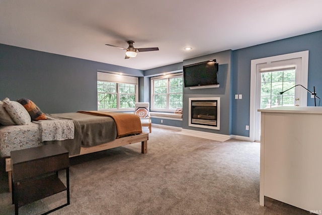 2200 E Boonville New Harmony Rd, Evansville, IN 47725 - carpeted bedroom with multiple windows, a fireplace with flush hearth, and a ceiling fan