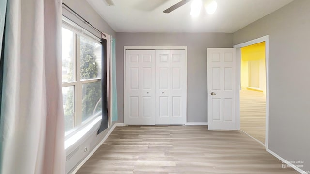 921 W Wheatfield Ln, Churubusco, IN 46723 - unfurnished bedroom featuring light wood finished floors, a closet, and a ceiling fan