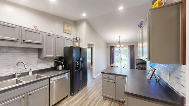 921 W Wheatfield Ln, Churubusco, IN 46723 - kitchen with stainless steel dishwasher, black fridge, vaulted ceiling, tasteful backsplash, and light wood-style floors