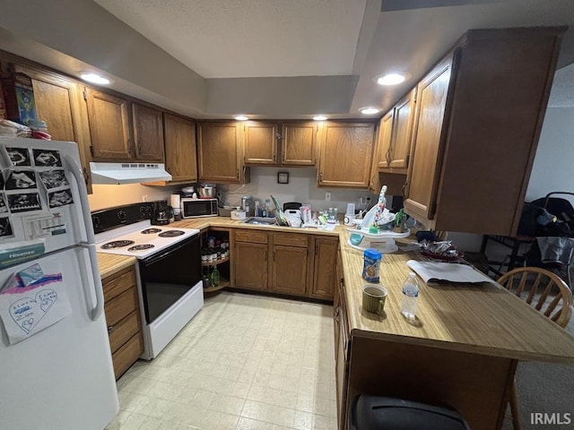 721 N 7th St, Vincennes, IN 47591 - kitchen featuring white appliances, under cabinet range hood, brown cabinets, and light countertops