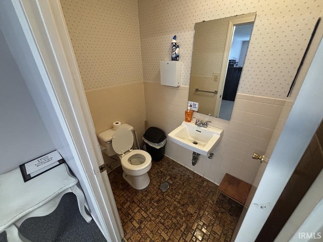 721 N 7th St, Vincennes, IN 47591 - bathroom with tile walls, wallpapered walls, and a wainscoted wall