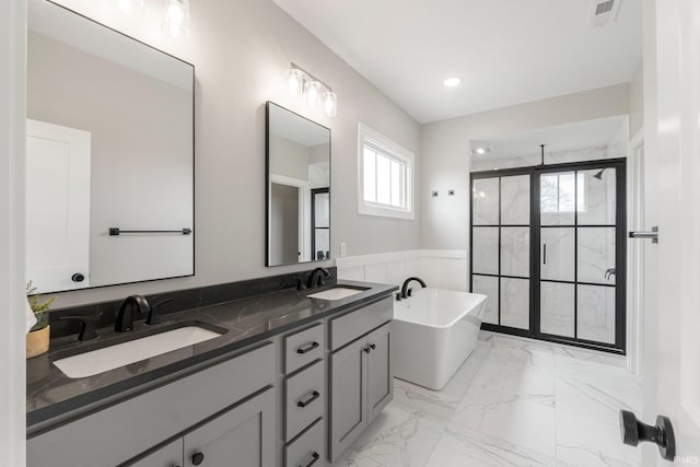 18015 Tullymore Ln, Leo, IN 46765 - full bathroom featuring a stall shower, a freestanding tub, double vanity, marble finish floors, and recessed lighting