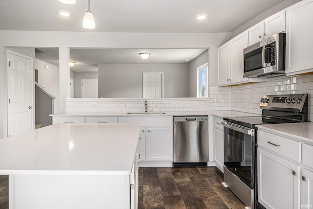 1417 Din Cv, Huntertown, IN 46748 - kitchen featuring appliances with stainless steel finishes, dark wood-type flooring, a peninsula, light countertops, and tasteful backsplash