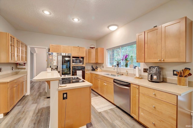 1045 E Chris Ln, Bloomington, IN 47401 - kitchen featuring appliances with stainless steel finishes, light brown cabinets, a textured ceiling, a center island, and light wood-type flooring