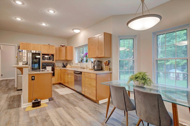 1045 E Chris Ln, Bloomington, IN 47401 - kitchen featuring stainless steel appliances, light brown cabinetry, light countertops, light wood-type flooring, and a textured ceiling