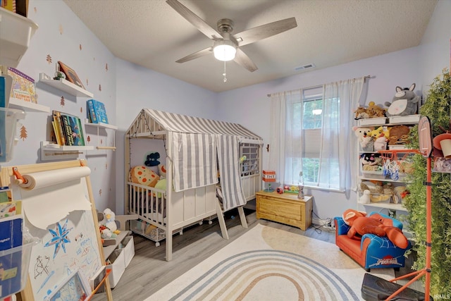 1045 E Chris Ln, Bloomington, IN 47401 - bedroom featuring wood finished floors, a textured ceiling, and ceiling fan