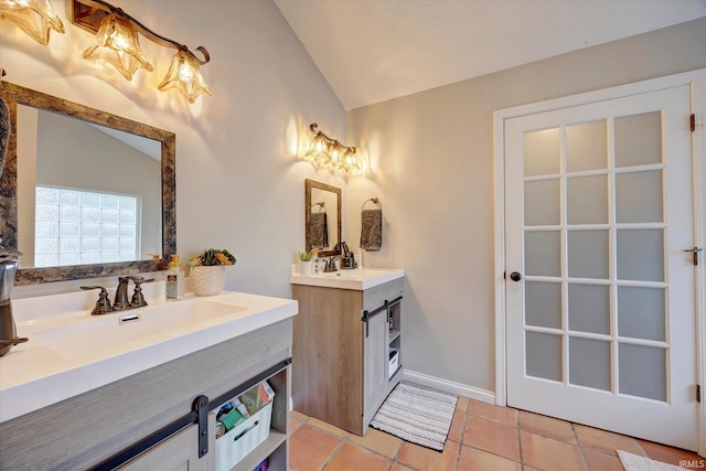 1045 E Chris Ln, Bloomington, IN 47401 - bathroom with lofted ceiling, two vanities, and tile patterned flooring