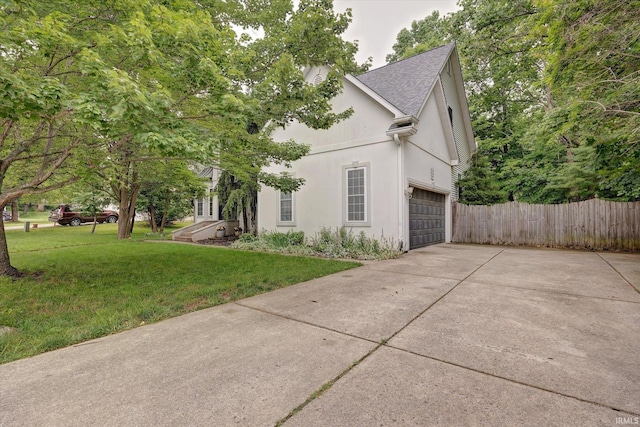 1045 E Chris Ln, Bloomington, IN 47401 - view of side of property featuring concrete driveway, stucco siding, an attached garage, and a shingled roof