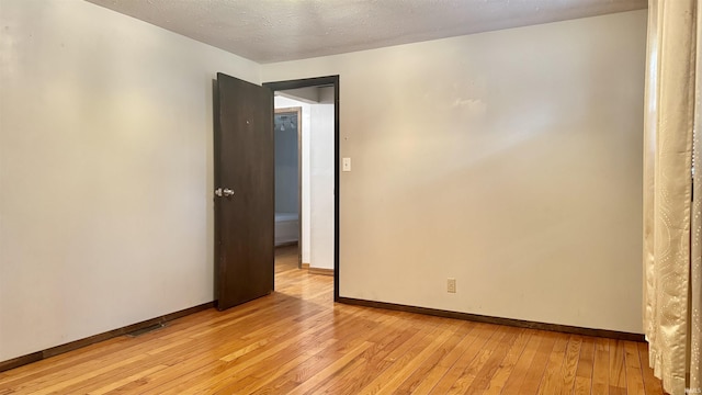 54213 Terrace Ln, South Bend, IN 46635 - empty room featuring light wood-style flooring and a textured ceiling