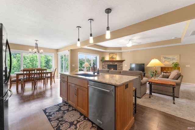 10057 Chapmans Cv, Fort Wayne, IN 46835 - kitchen featuring dishwasher, freestanding refrigerator, a brick fireplace, a ceiling fan, and a kitchen island with sink