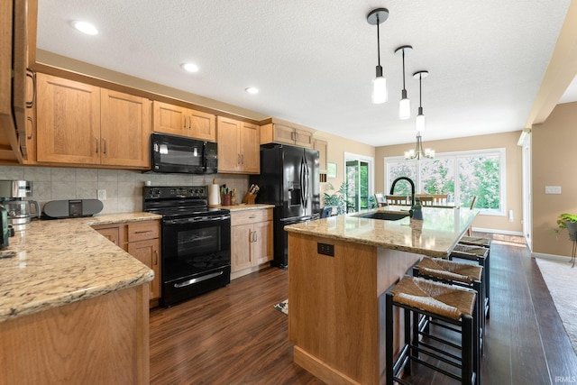 10057 Chapmans Cv, Fort Wayne, IN 46835 - kitchen featuring black appliances, dark wood-type flooring, decorative backsplash, a kitchen breakfast bar, and recessed lighting