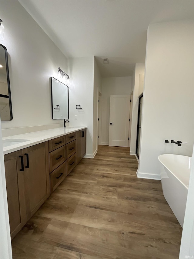1609 Diane Dr, Ossian, IN 46777 - bathroom with double vanity, a soaking tub, and wood finished floors