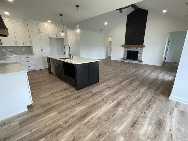 1609 Diane Dr, Ossian, IN 46777 - kitchen with white cabinetry, light wood-style floors, a kitchen island with sink, light countertops, and recessed lighting